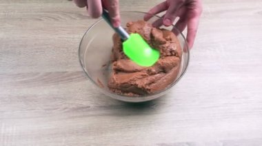 Tereyağlı ve kakaolu kurabiyeleri karıştırıyorum. Yoğunlaştırılmış süt, kakao ve kurabiyelerden tatlı çikolata sosisi yapıyorum. Ev yemeği kavramı.