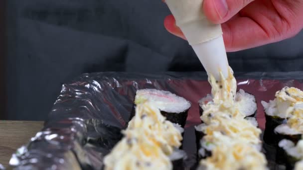 家庭でロールや寿司を作る さまざまな製品からロールを調理することを学ぶ若いシェフ 日本料理のコンセプト — ストック動画