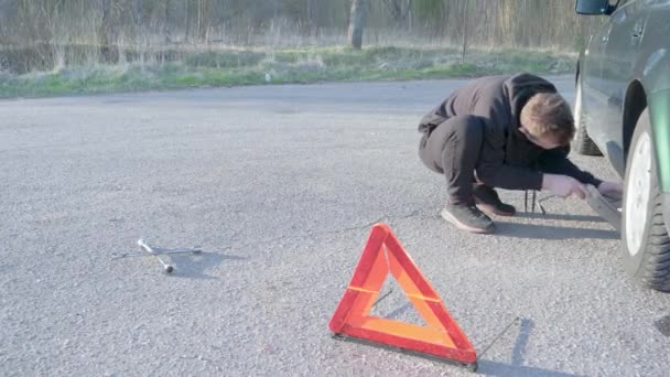 Ung Kille Sätter Knekt Och Höjer Bilen Han Bär Svart — Stockvideo