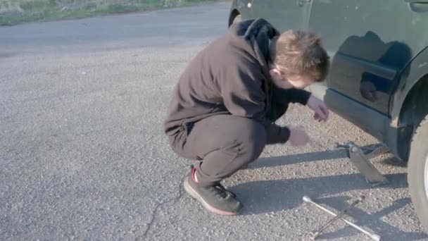 Joven Pone Gato Levanta Coche Lleva Chándal Negro Zapatillas Negras — Vídeos de Stock