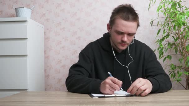 Een Jongeman Luistert Naar Muziek Schrijft Hij Draagt Een Zwart — Stockvideo