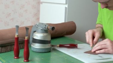 Evde çalışan genç deri işçisi, deri, deri imalatçısı, tabakçı ve deri işlerinde usta.