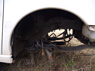 Ön tekerleği olmayan beyaz boncuk, arabanın ön dingili görünür, yolda araba tamir etme kavramı....