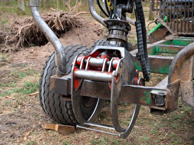 Kesilen ağaçları, yakın plan kovaları, ağaç kesme konseptini, ormansızlaşmayı toplayan traktör..