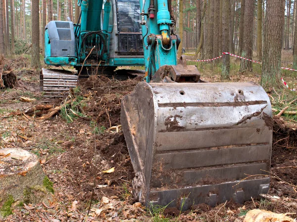 Traktör bir kova ile toprağı kazıyor, kova yakın plan, ağaç kesme konsepti, ormansızlaştırma.