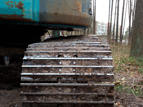 Traktör bir kova ile toprağı kazıyor, tırtıla yakın çekim, ağaç kesme konsepti, ormanların yok edilmesi..