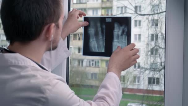 Joven Médico Mirando Una Radiografía Sobre Fondo Una Ventana Sobre — Vídeo de stock