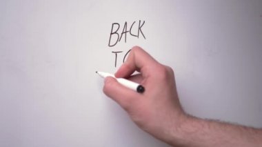Beyaz bir adamın eli beyaz bir manyetik tahtaya kelimeler, çalışma ve mesafe öğrenme kavramını yazıyor.
