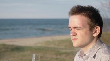 Bir adam randevuda bir kızı bekliyor, beklemekten sıkılmış, şampanya içiyor, tişört ve eşofman giyiyor, buluşma ve randevu kavramı, bekliyor.