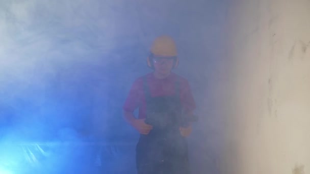 パフォーマーを手に煙の雲から建築家が出現し 建設服と硬い帽子を身に着けて 建設コンセプト 電気を敷設します — ストック動画
