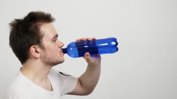 Ένας Νεαρός Αθλητικός Τύπος Πίνει Νερό Από Ένα Μπλε Μπουκάλι — Αρχείο Βίντεο