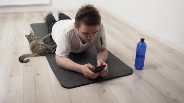 Joven Deportista Está Navegando Por Internet Teléfono Mientras Gatito Está — Vídeos de Stock