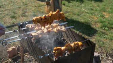 Izgara et, ızgarada barbekü, arka planda yeşil çimenler.