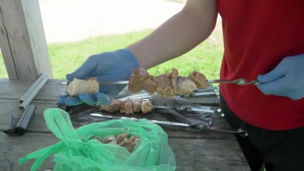 バーベキューグリルで調理するためのケバブを準備男性の手 自然レクリエーションや料理の概念 — ストック動画