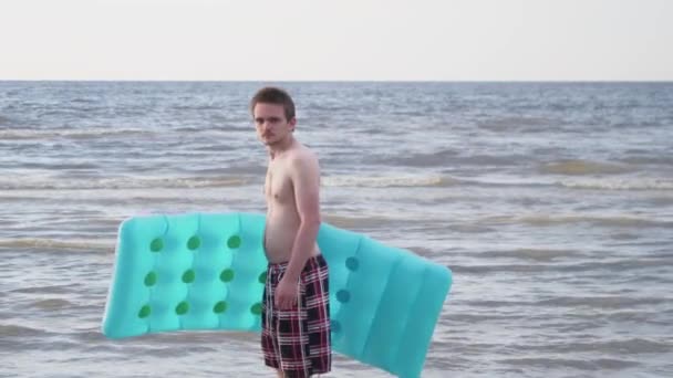 Young White Guy Red Shorts Inflatable Mattress His Hands Walks — Vídeo de Stock