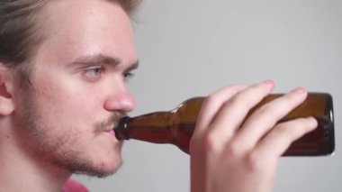 Genç yakışıklı sakallı adam televizyon izliyor. Adamın yüzü yakın, duyguları var. Eğlence, eğlence, video oyunları, televizyon konsepti. Patlamış mısır ve bira