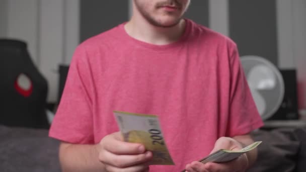穿着红T恤的人在数着欧元钞票 数着钞票 数着钞票的数目 领着薪水的概念 生意的概念 财务和债务 — 图库视频影像