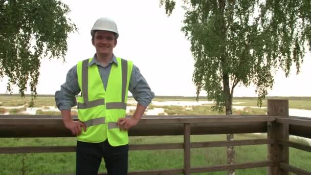 Joven Constructor Ecologista Mira Cámara Sonríe Video Retrato Está Vestido — Vídeos de Stock