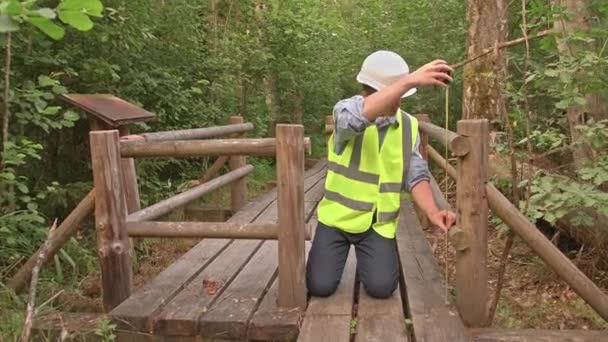 Joven Constructor Ecologista Mide Una Estructura Madera Lleva Chaleco Reflectante — Vídeos de Stock