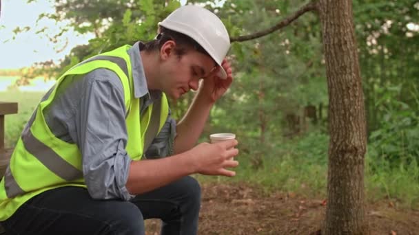 Trött Ung Ekolog Byggare Dricker Kaffe Tar Sig Hjälmen Och — Stockvideo