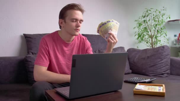Ung Fyr Sidder Sofaen Ved Bordet Med Bærbar Computer Vinker – Stock-video