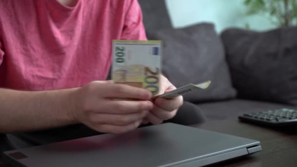Masanın Yanındaki Kanepede Oturan Genç Adam Dizüstü Bilgisayar Giderleri Için — Stok video