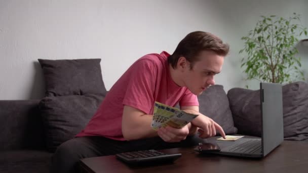 Junger Mann Sitzt Mit Laptop Auf Der Couch Tisch Und — Stockvideo