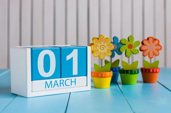 1 de marzo. Imagen del 1 de marzo calendario de color madera con flor sobre fondo blanco. Primer día de primavera, espacio vacío para el texto — Foto de Stock