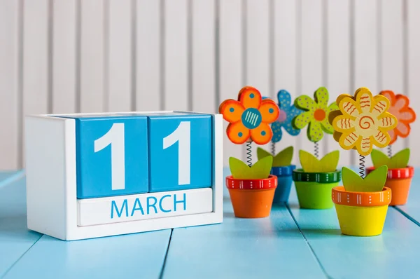 11 de marzo. Imagen del 11 de marzo calendario de color madera con flor sobre fondo blanco. Primavera de Europa, espacio vacío para texto — Foto de Stock