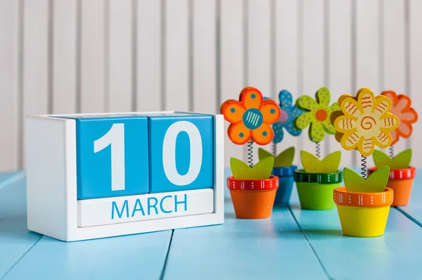 10. března. Obraz březen 10 dřevěné barevné kalendáře s květem na bílém pozadí. Jarní den, prázdné místo pro text — Stock fotografie