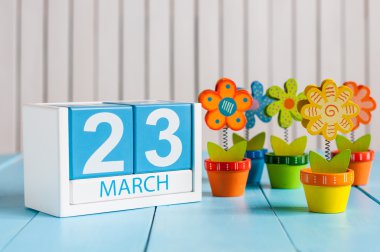 23 Mart. 23 Mart renk çiçek ile ahşap yüzey için küp takvim. Bahar kavramı