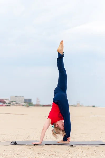 Sportovní womang podporované kotoul, jóga asana na pobřeží pozadí — Stock fotografie