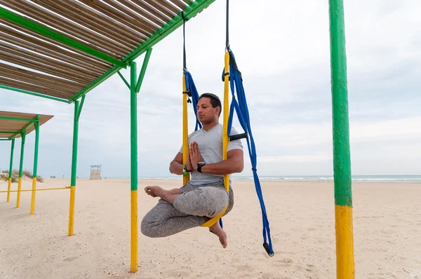 Fly Yoga, man doing yoga exercises on the sea background. Sport and healthy concept