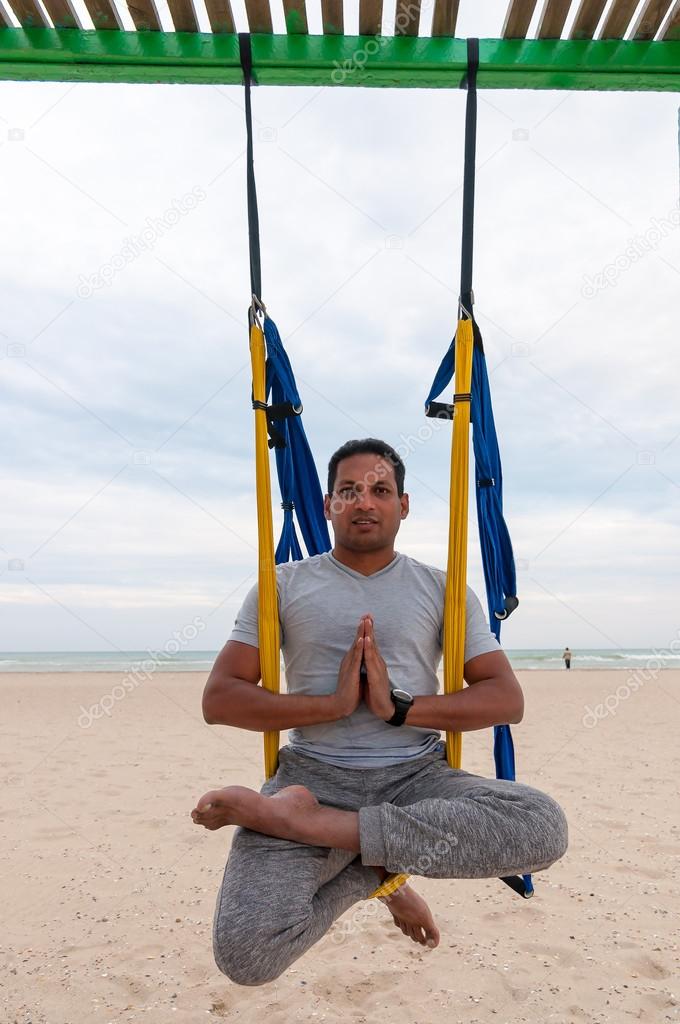 Fly Yoga, man doing yoga exercises on the sea background. Sport and healthy concept