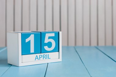 April 15th. Tax Day. Image of april 15 wooden color calendar on white background.  Spring day, empty space for text