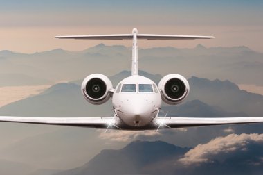 Bulutlar ve günbatımı dağda Alpler üzerinden uçak fly. Bir büyük yolcu ve yük uçak, iş jeti, havayolu önden görünümü. Ulaşım, seyahat kavramı