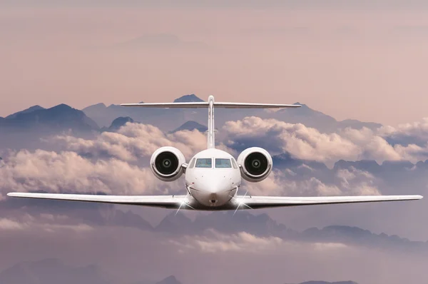 Concept de voyage. Vue de face de l'avion de ligne Jet en vol avec ciel, nuages et fond de montagne. Avions commerciaux de passagers ou de fret, jet d'affaires survolant les Alpes . — Photo