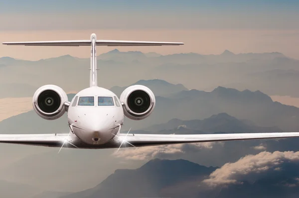 Travel by aircraft. Airplane fly over clouds and Alps mountain on down. Front view of a big passenger or cargo plane, business jet, airline. Transportation concept. Empty space for text