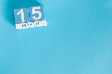 15 Mart. Mavi arka plan üzerinde 15 Mart ahşap renkli takvim görüntüsü. Bahar günü, metin için boş alan. Dünya Tüketici Hakları Günü