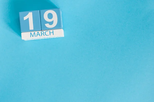 19. März. Bild vom 19. März Holzkalender mit Blume auf blauem Hintergrund. Frühlingstag. Earth Hour und internationaler Kliententag — Stockfoto