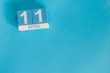 11 Nisan. Mavi arka plan üzerinde 11 Nisan ahşap renkli takvim görüntüsü. Bahar günü, metin için boş alan. Uluslararası Faşist Toplama Kampları Günü Esirlerin Kurtuluşu