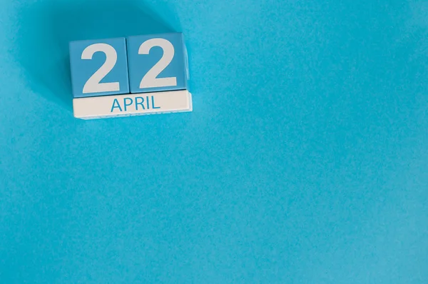 22. huhtikuuta. Maan päivä. Kuva huhtikuu 22 puinen väri kalenteri sinisellä pohjalla. Kevätpäivä, tyhjä tila tekstille — kuvapankkivalokuva