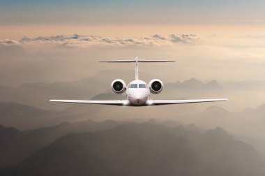 Bulutlar ve günbatımı dağda Alpler üzerinden uçak fly. Bir büyük yolcu ve yük uçak, iş jeti, havayolu önden görünümü. Ulaşım, seyahat kavramı