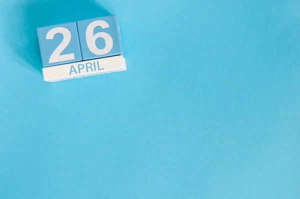 Le 26 avril. Image du 26 avril calendrier de couleurs en bois sur fond bleu. Printemps, espace vide pour le texte — Photo