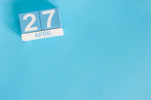 27 april. Bild av april 27 trä färg kalender på blå bakgrund. Vårdag, tomt utrymme för text — Stockfoto