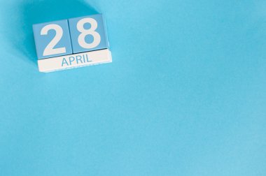 28 Nisan. Vergi Günü. Mavi arka plan üzerinde 28 Nisan ahşap renkli takvim görüntüsü. Bahar günü, metin için boş alan