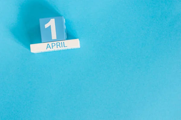 1. April. Bild des hölzernen Kalenders vom 1. April auf blauem Hintergrund. Frühlingstag, leerer Raum für Text. aller närrische Tag — Stockfoto