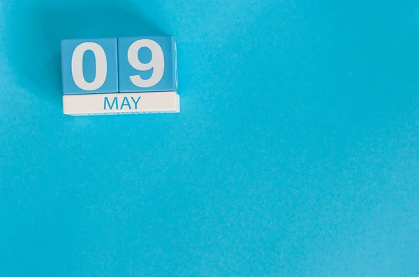 9 Μαΐου. Εικόνα 9 Μαΐου ξύλινο χρώμα ημερολογίου σε μπλε φόντο. Άνοιξη της Ευρώπης, κενό χώρο για κείμενο. Σύμβολα της νίκης στο Β΄ Παγκόσμιο Πόλεμο — Φωτογραφία Αρχείου