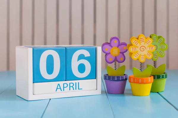Le 6 avril. Image du 6 avril calendrier de couleurs en bois sur fond blanc avec des fleurs. Printemps, espace vide pour le texte — Photo