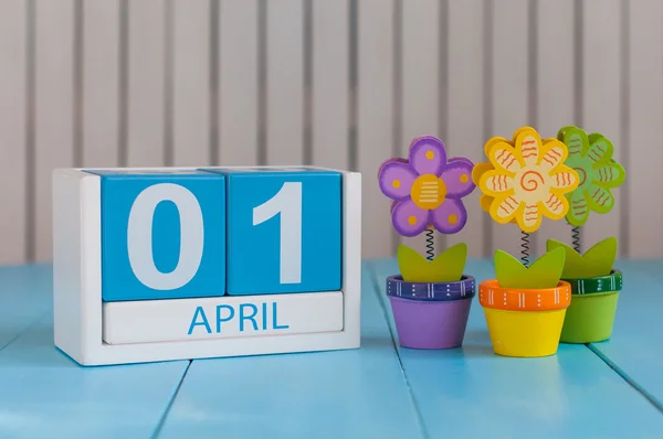 1 aprile. Immagine di 1 aprile calendario a colori in legno su sfondo bianco con fiori. Giorno di primavera, spazio vuoto per il testo. Tutti i Fools Day — Foto Stock